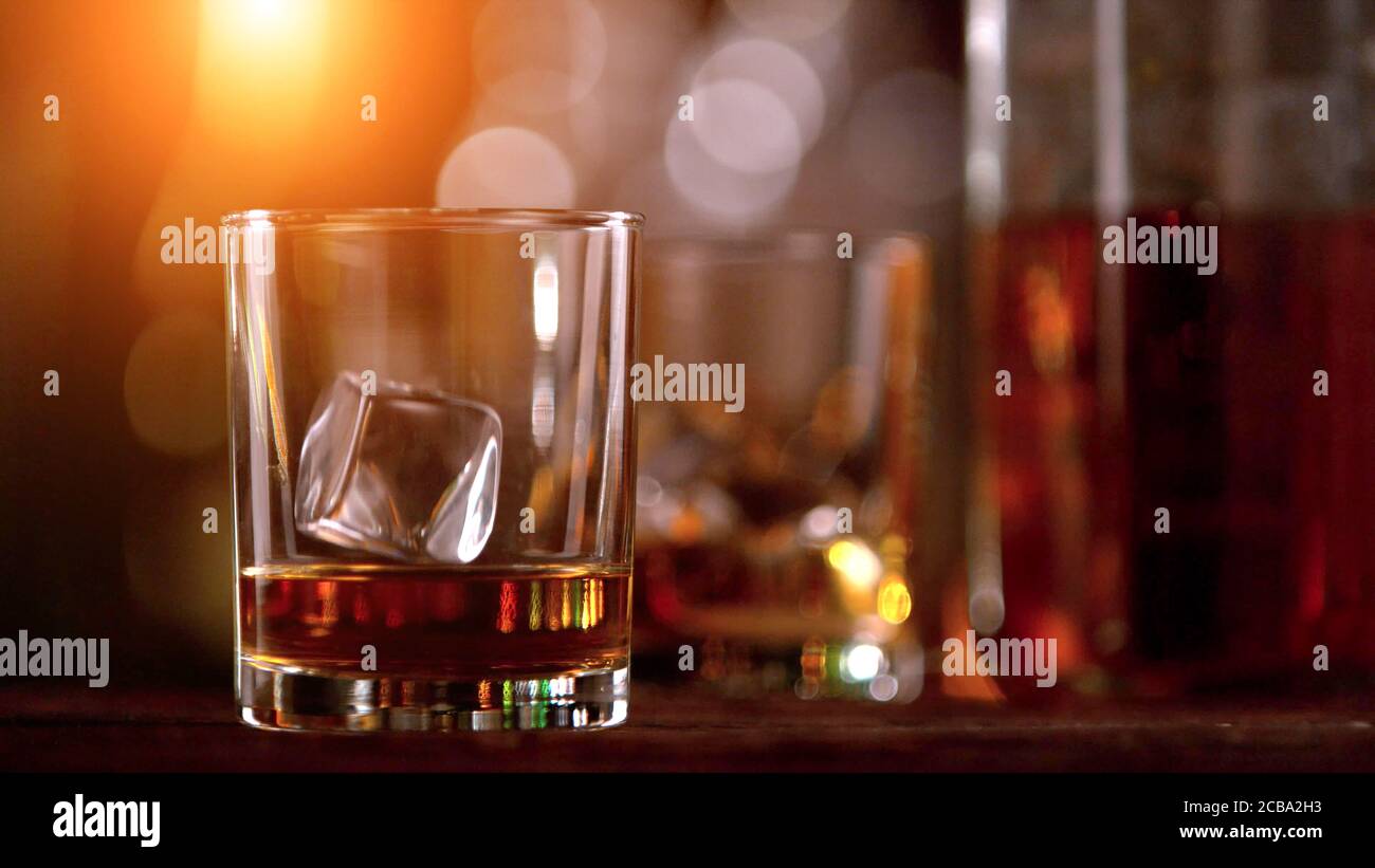 Whisky bevande con rocce di ghiaccio volanti. Posto su fusto di legno. Bassa profondità di messa a fuoco Foto Stock