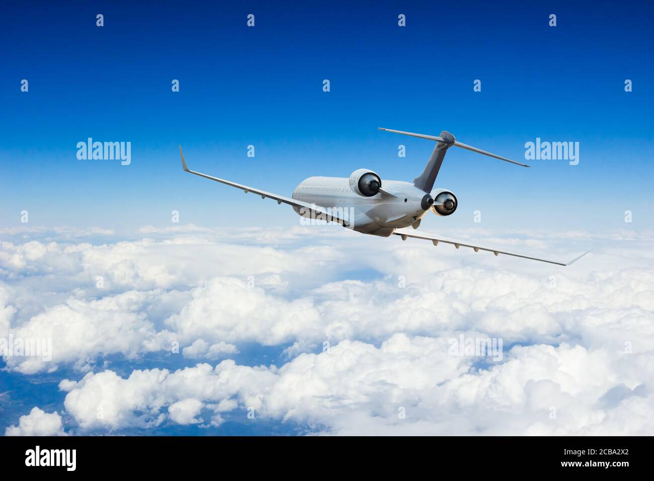 Passeggeri aerei commerciali che volano sopra le nuvole. Concetto di viaggio veloce, vacanze e affari. Foto Stock