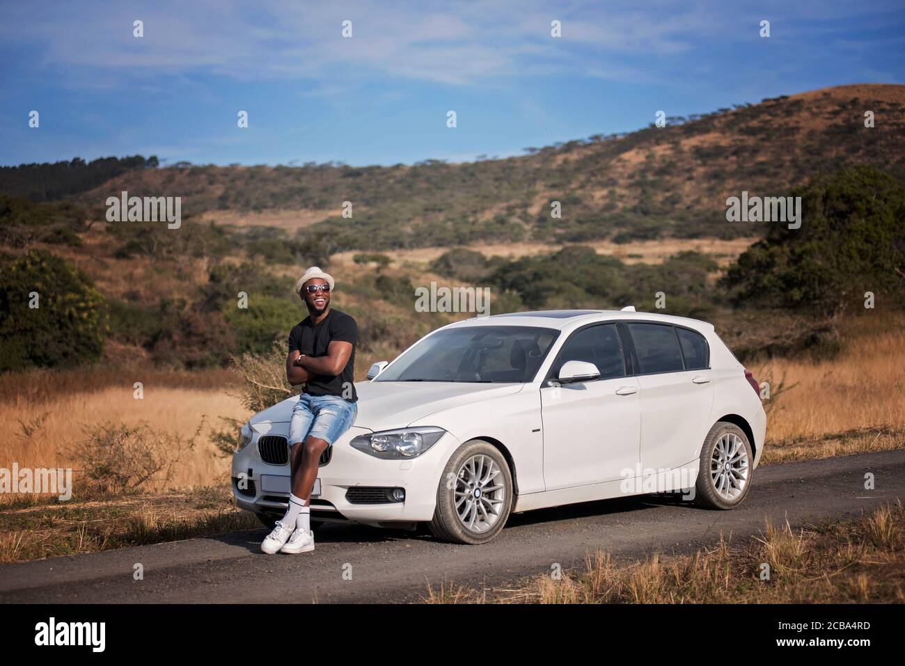 Uomo nero africano o afroamericano di successo su safari con auto di lusso Foto Stock