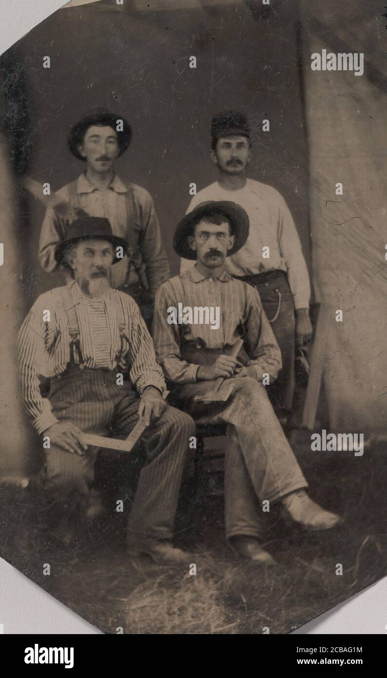 Quattro operai che hanno in mano diversi attrezzi: Quadrato, Hatchet, piano di legno e cazzuola, 1860s-70s. Foto Stock