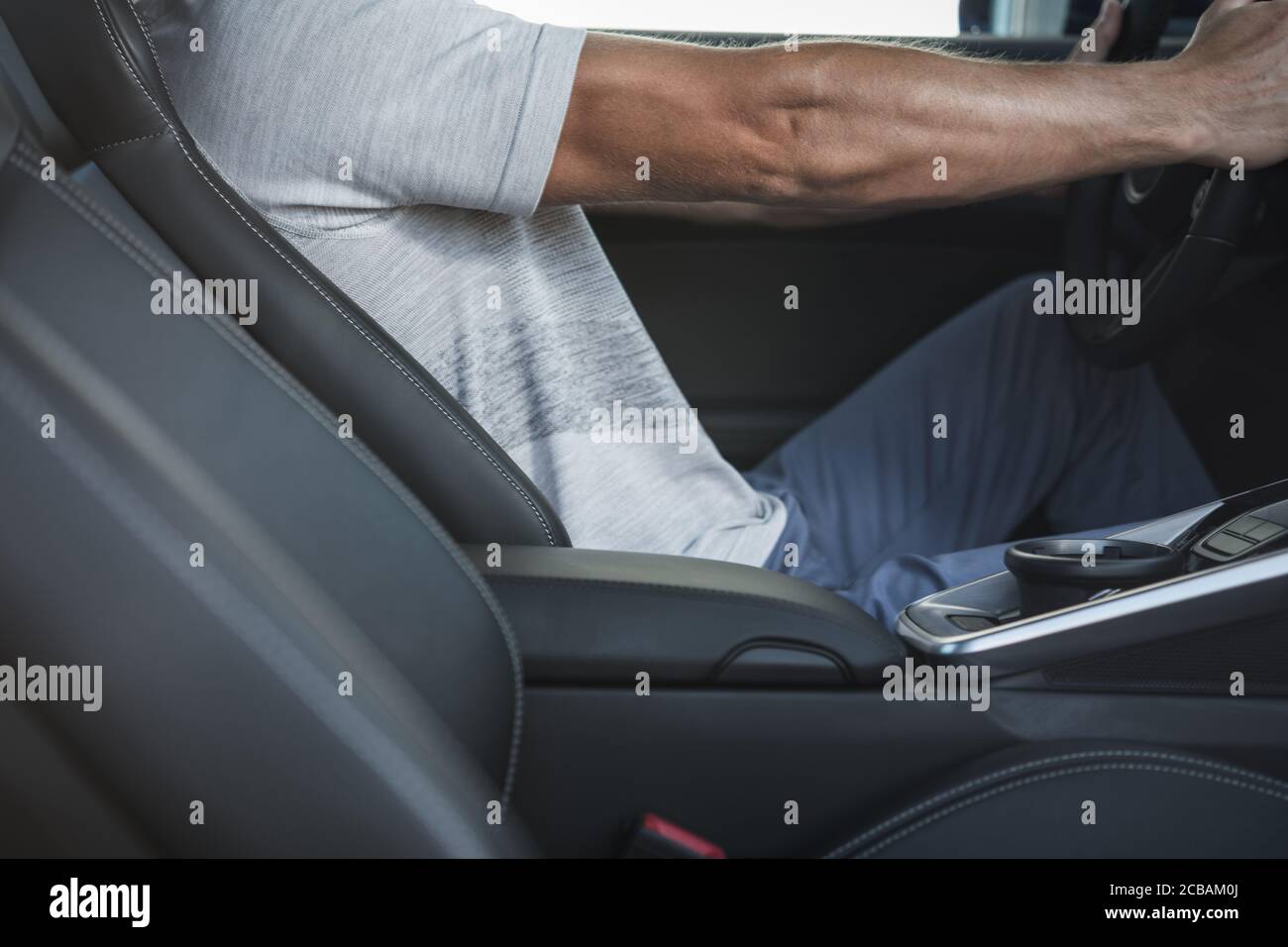 Ergonomia all'interno di un veicolo moderno. Caucasici uomini nel suo 40s alla guida della sua Premium Car. Posizione del corpo del conducente dietro il volante della vettura. Automotive e tra Foto Stock