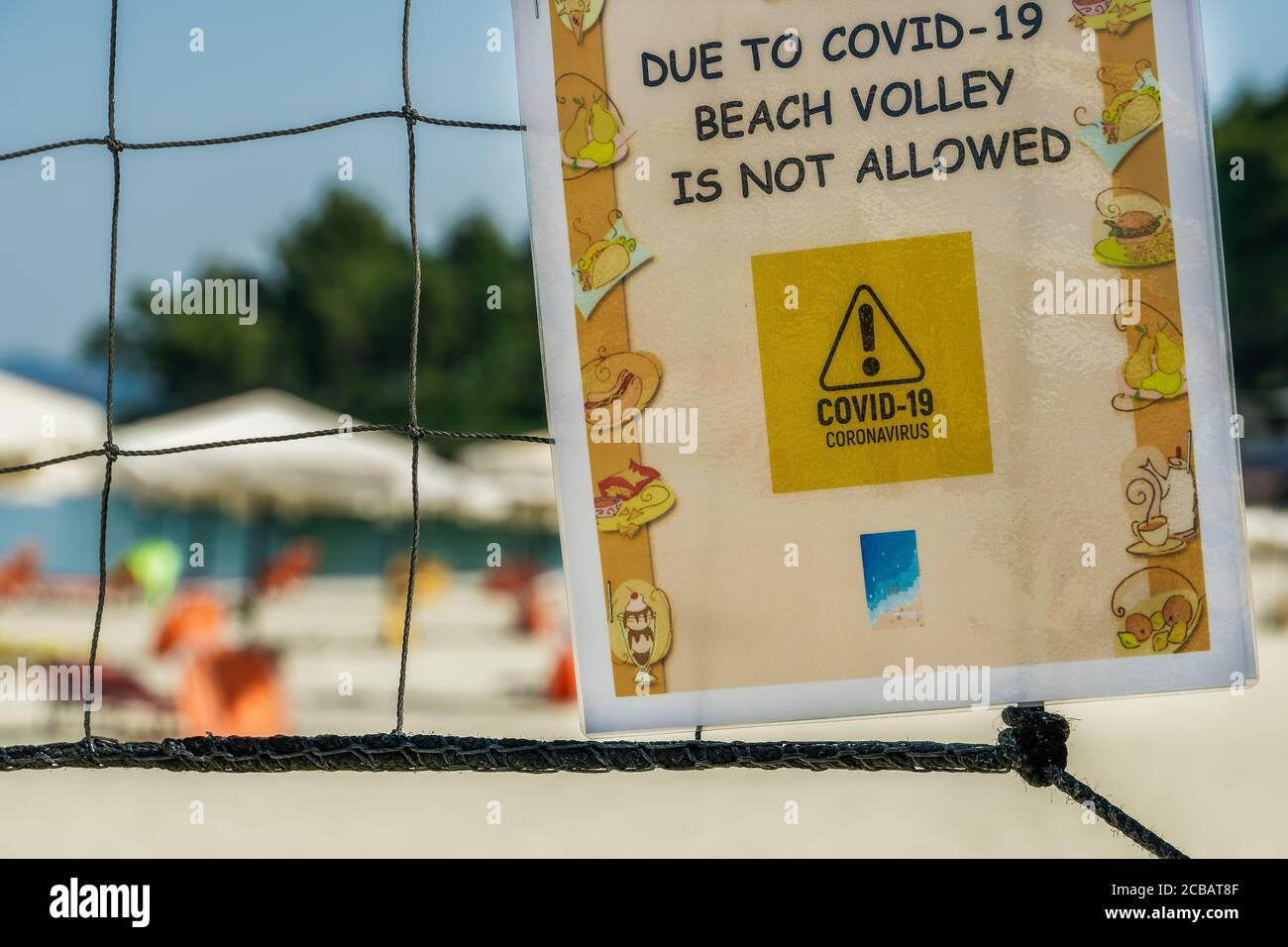 CHALKIDIKI, Greece Covid-19 Beach volley non è permesso segno. Informazioni cartacee su una rete esterna che vieta le attività sportive estive, per proteggere dai virus Foto Stock