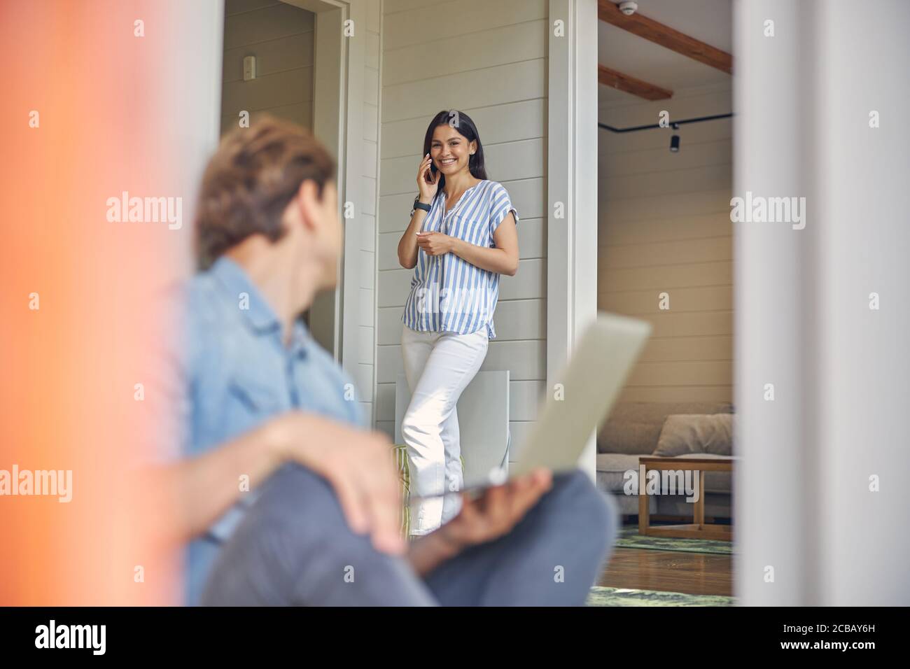 Sorridente donna caucasica che parla al telefono Foto Stock