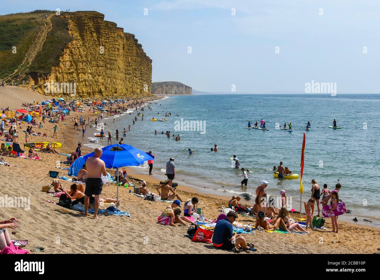 West Bay, Dorset, Regno Unito. 12 agosto 2020. Regno Unito Meteo. I turisti e i bagnanti si affollano sulla spiaggia presso la località balneare di West Bay a Dorset in un'altra giornata di sole e caldo mentre l'onda di calore continua. Picture Credit: Graham Hunt/Alamy Live News Foto Stock