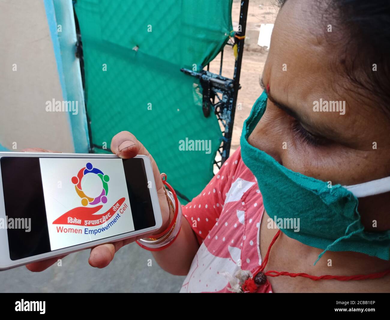 DISTRETTO KATNI, INDIA - 28 MAGGIO 2020: Un villaggio indiano Donna che tiene smartphone con visualizzazione delle donne empowerment schema cellulare sullo schermo, iniziato da Foto Stock