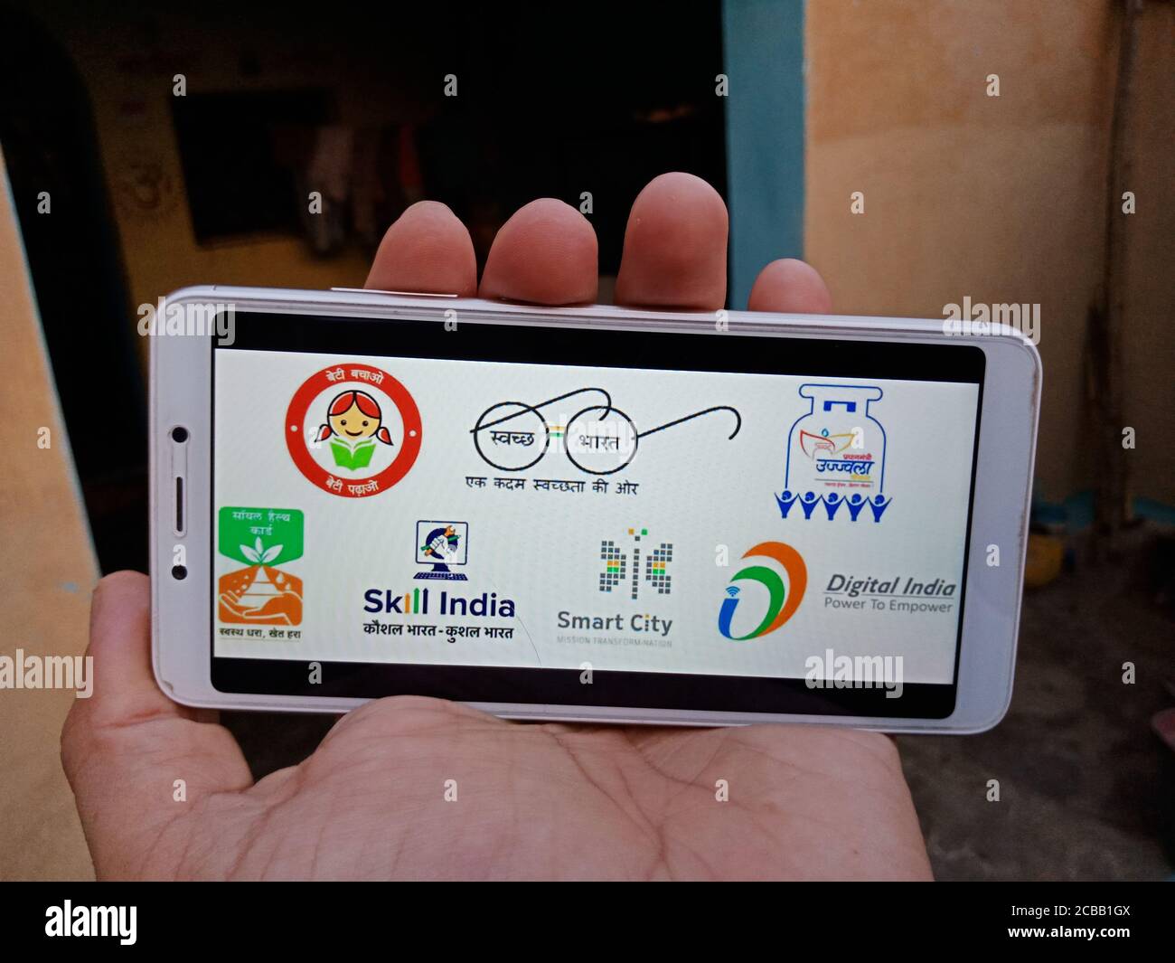 DISTRETTO KATNI, INDIA - 28 MAGGIO 2020: Una signora del villaggio indiano che tiene lo smartphone con la visualizzazione di schemi multipli sullo schermo, avviato dal governo di Foto Stock
