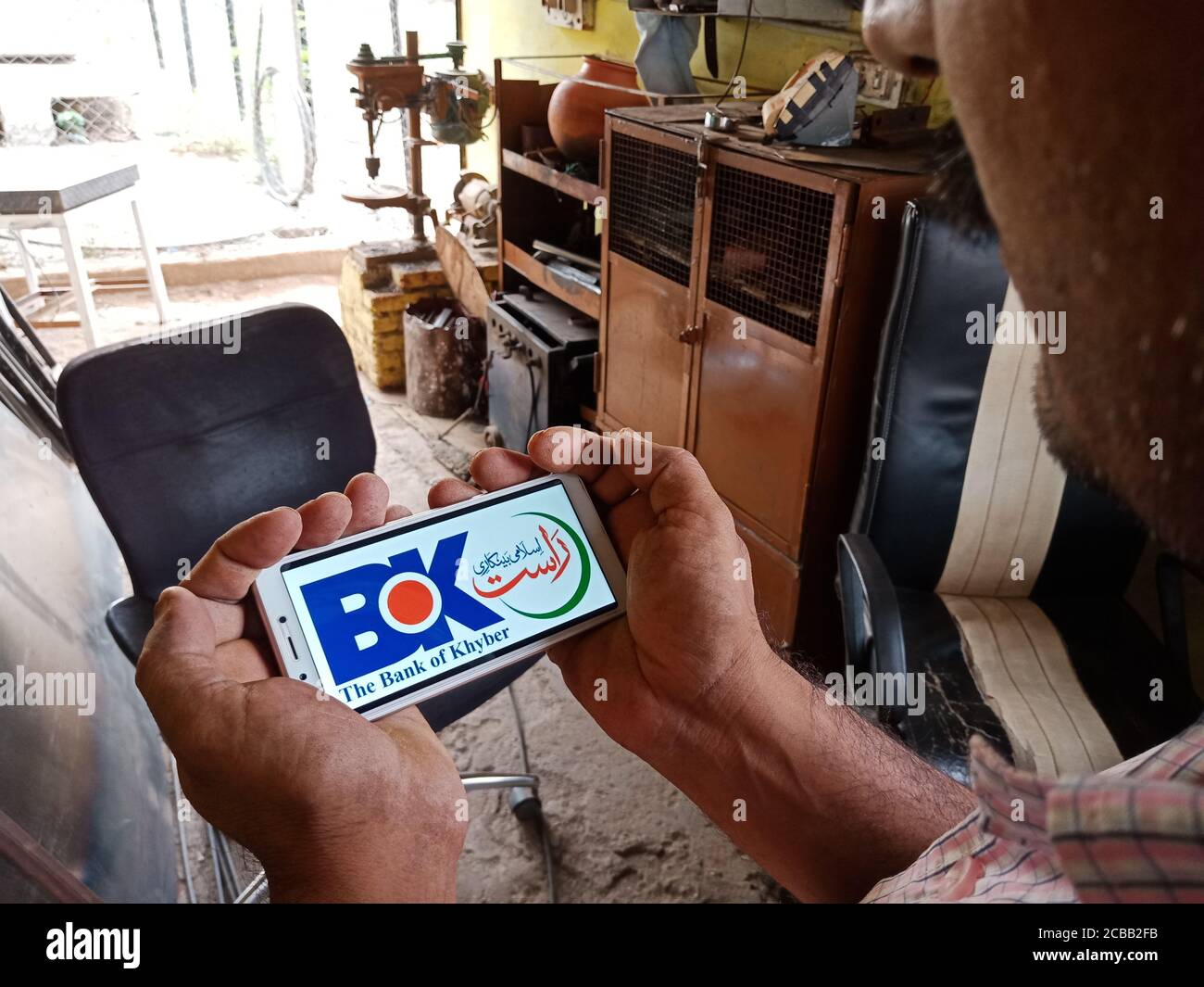 DISTRETTO KATNI, INDIA - 02 GIUGNO 2020: Un uomo indiano che detiene smartphone con la visualizzazione della banca del logo khyber sullo schermo, istruzione bancaria moderna c Foto Stock