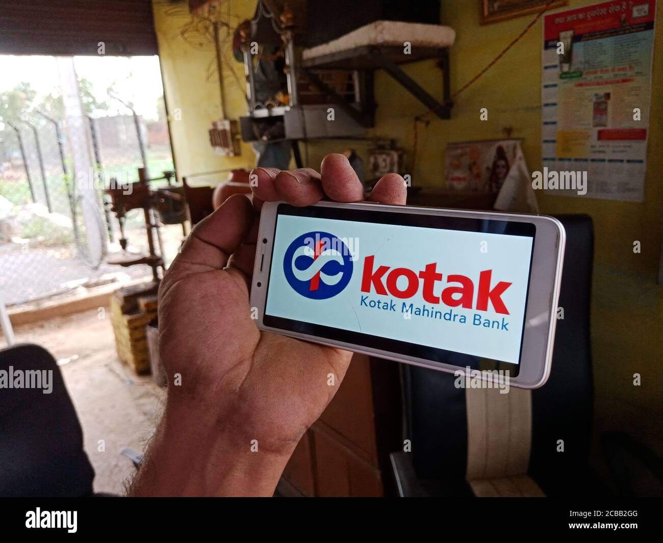 DISTRETTO KATNI, INDIA - 02 GIUGNO 2020: Un uomo indiano che detiene smartphone con visualizzazione del logo della banca kotak mahindra sullo schermo, istruzione bancaria moderna Foto Stock