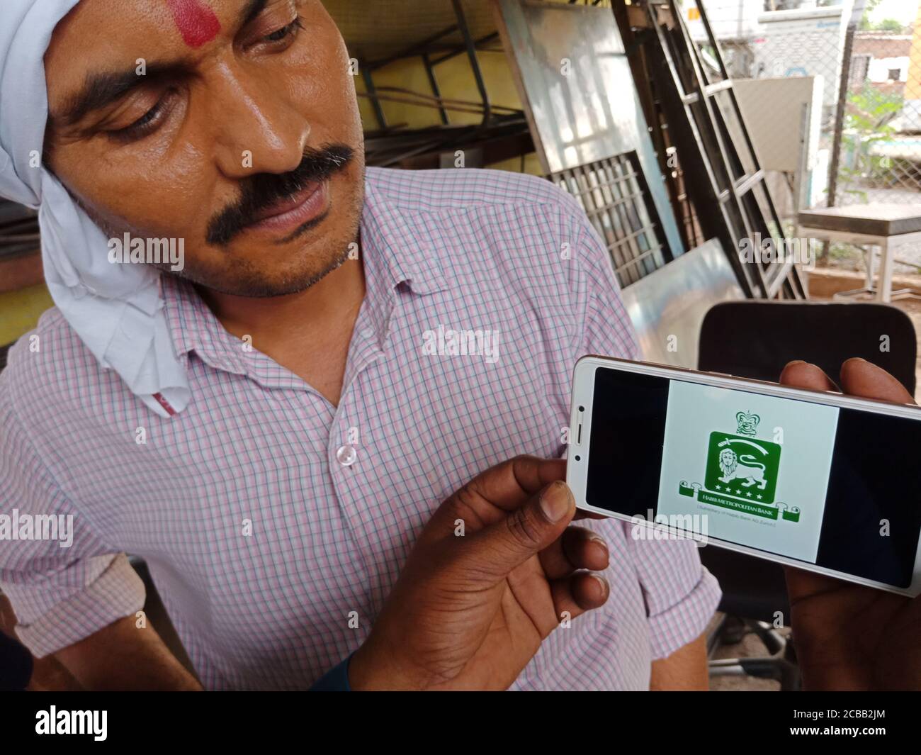 DISTRETTO KATNI, INDIA - 02 GIUGNO 2020: Un uomo indiano che detiene smartphone con visualizzazione del logo della banca metropolitana habib sullo schermo, russo educa banking Foto Stock