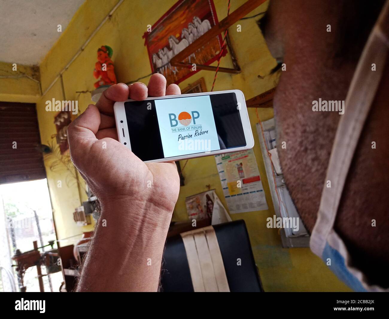 DISTRETTO KATNI, INDIA - 02 GIUGNO 2020: Un uomo indiano che detiene smartphone con la visualizzazione della banca del logo punjab sullo schermo, istruzione bancaria moderna c Foto Stock