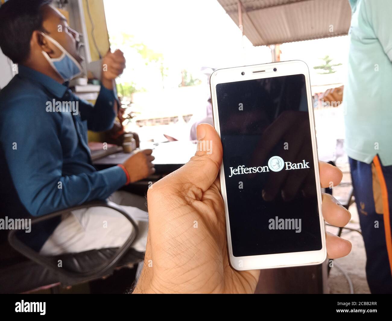 DISTRETTO KATNI, INDIA - 02 GIUGNO 2020: Un uomo indiano che detiene smartphone con visualizzazione del logo della banca jefferson sullo schermo, moderno russo bancario educati Foto Stock