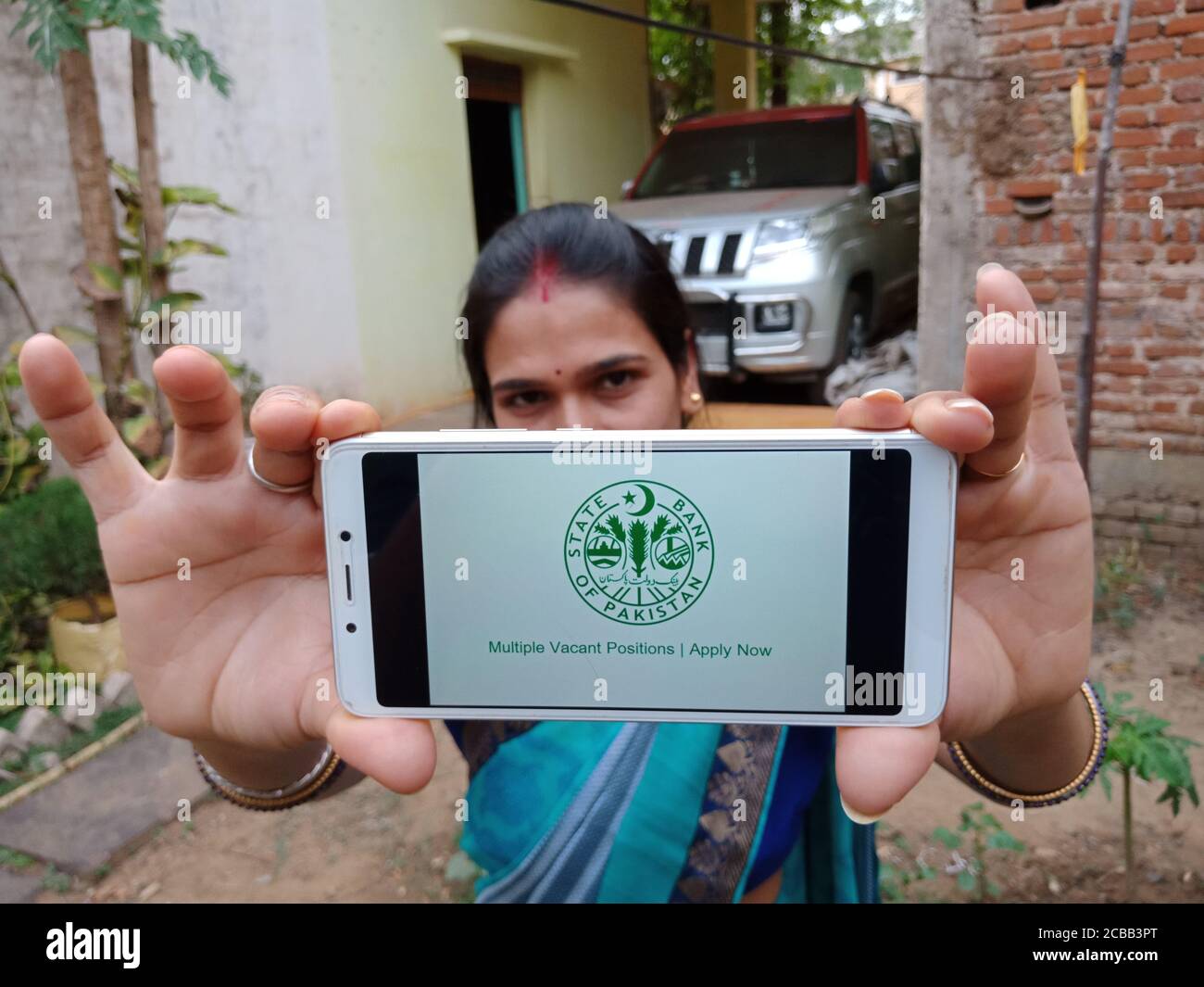 DISTRICT KATNI, INDIA - 02 GIUGNO 2020: Una donna indiana che detiene smartphone con visualizzazione del logo della società della banca centrale del Pakistan sullo schermo, Foto Stock