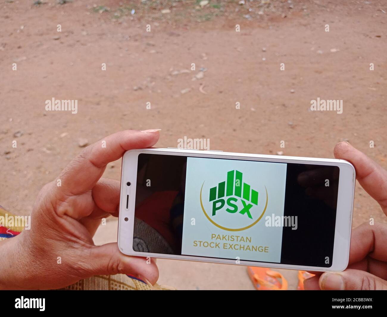 DISTRETTO KATNI, INDIA - 02 GIUGNO 2020: Una donna indiana che detiene smartphone con visualizzazione del logo della Borsa di Pakistan sullo schermo, moderno settore bancario Foto Stock