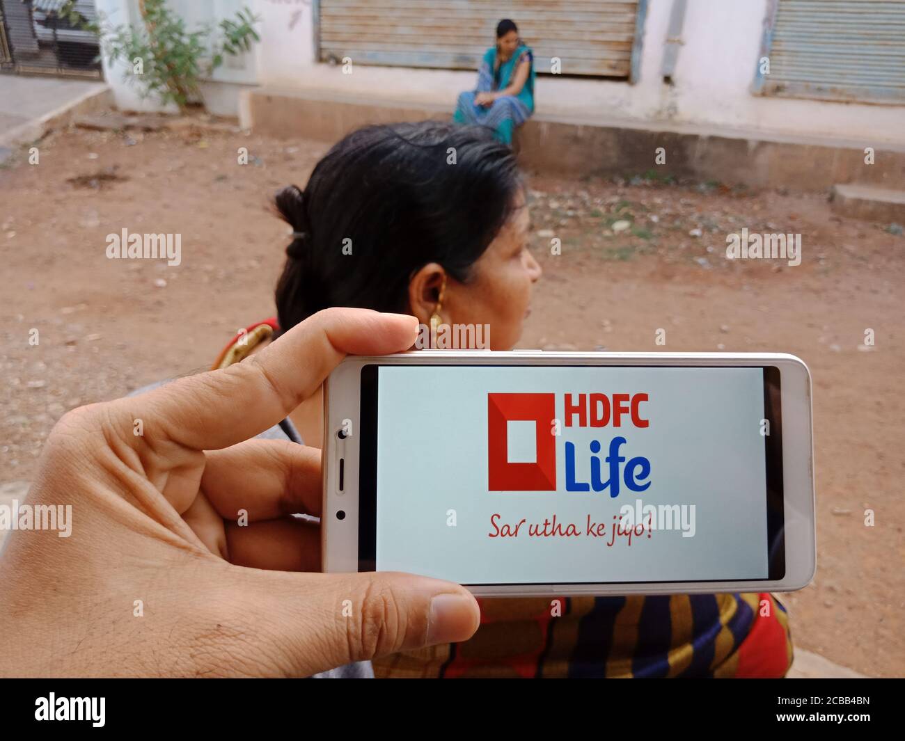 DISTRETTO KATNI, INDIA - 02 GIUGNO 2020: Una donna indiana che detiene smartphone con visualizzazione HDFC vita società di assicurazione logo sullo schermo, banca moderna Foto Stock