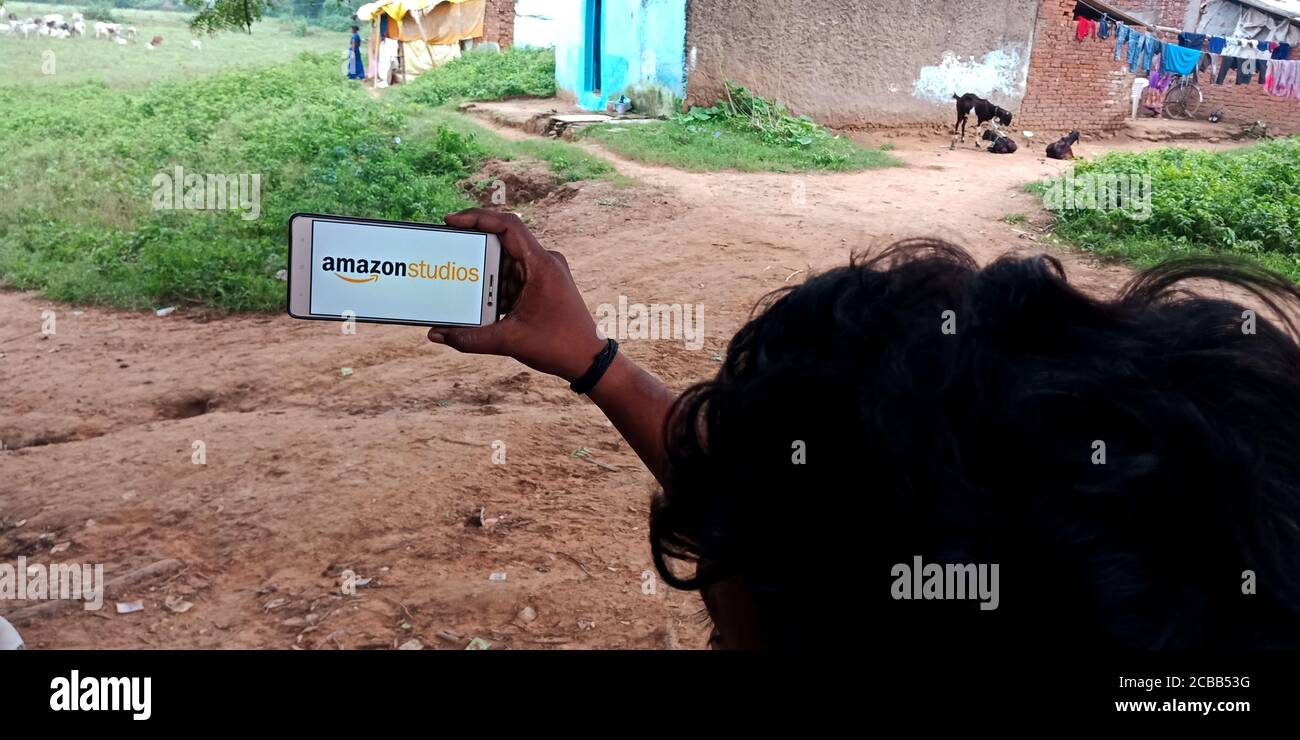 DISTRICT KATNI, INDIA - 18 SETTEMBRE 2019: Logo del distributore Amazon Studios Film visualizzato sullo schermo dello smartphone da parte di uomo villaggio indiano mano holding mo Foto Stock