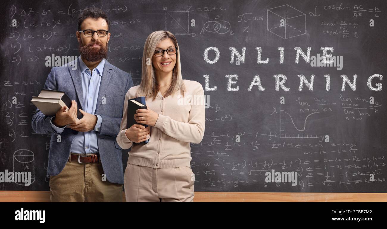Insegnanti di sesso maschile e femminile di fronte a una lavagna con apprendimento online con testo Foto Stock