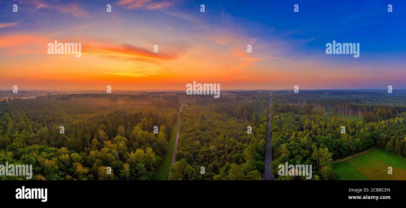 Alba aerea su una grande foresta con luce naturale arancione, una mattina meravigliosa in una vista panoramica nel sud della germania. Foto Stock