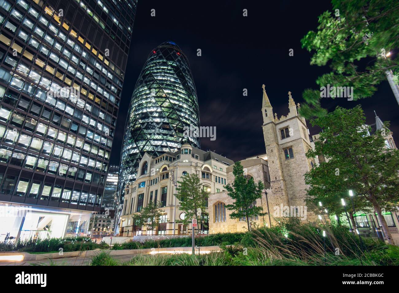 Vista del famoso edificio di Gherkin e della chiesa di Sant'Andrea di notte Foto Stock