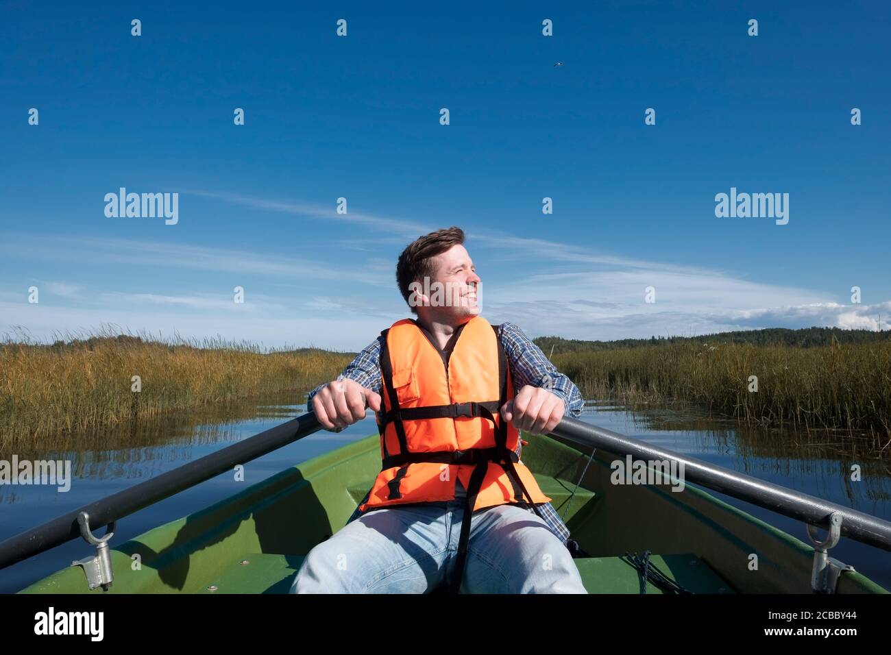 Un giovane in una giacca di vita si siede in un barca Foto Stock