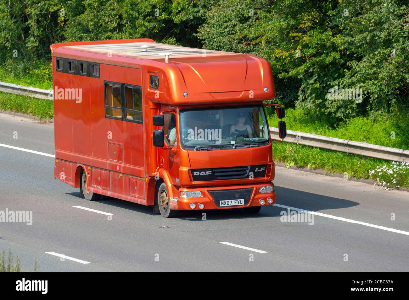 2007 furgone da cavalli DAF LF Orange; trasporto di animali equini costruiti e di conversione in pullman che viaggiano sull'autostrada M6, Lancashire, Regno Unito Foto Stock