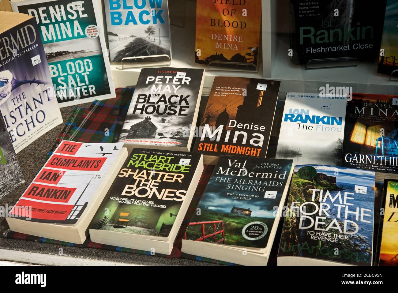 Selezione di libri cartacei per reati di seconda mano di scrittori scozzesi nella finestra di un negozio Oxfam a Edimburgo, Scozia, Regno Unito. Foto Stock