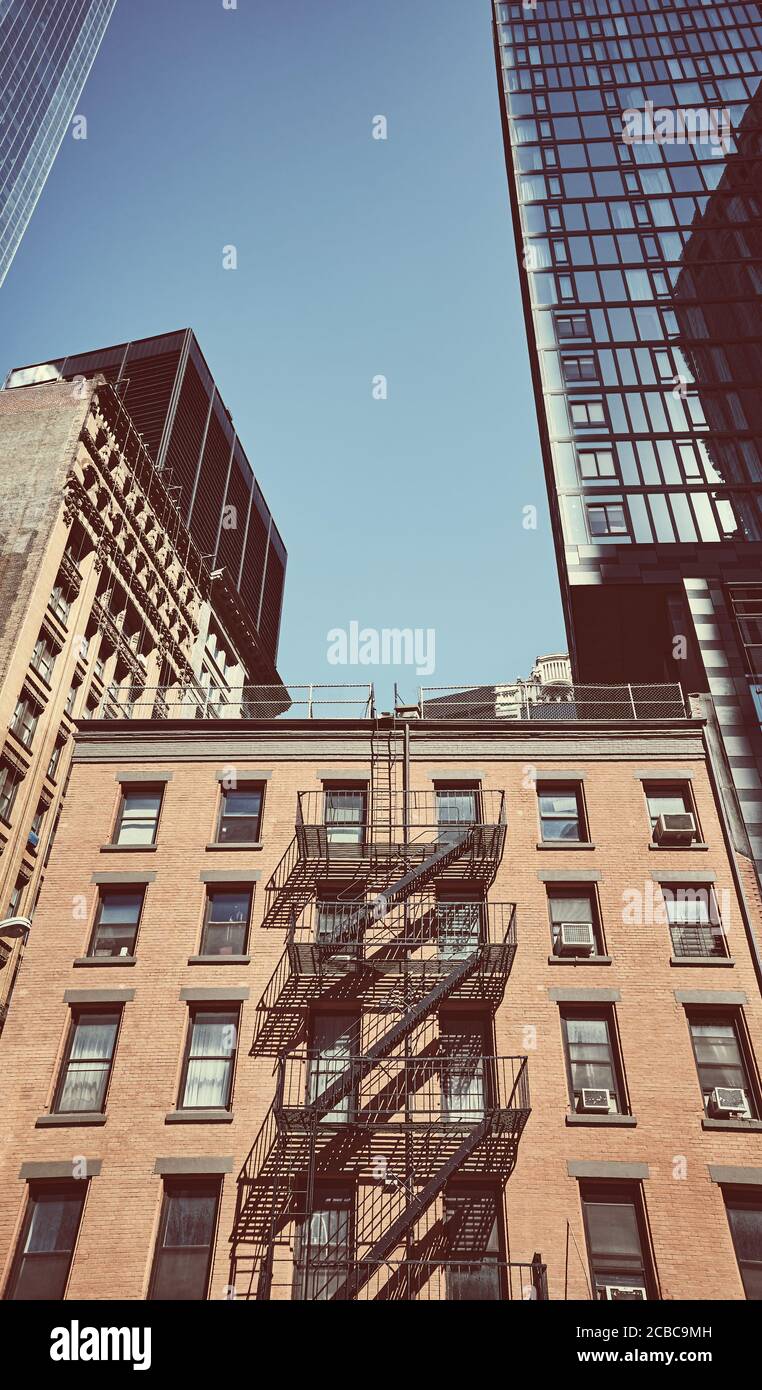 Vecchia casa in mattoni tra grattacieli moderni a New York City, colore applicato toning, Stati Uniti. Foto Stock