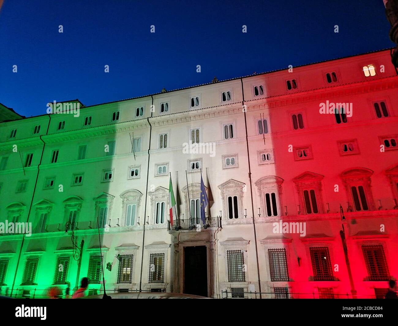 Roma, Italia - 12 agosto 2020: Emergenza Coronavirus in Italia, Palazzo Chigi, sede del governo italiano, illuminata con i colori della bandiera italiana Foto Stock