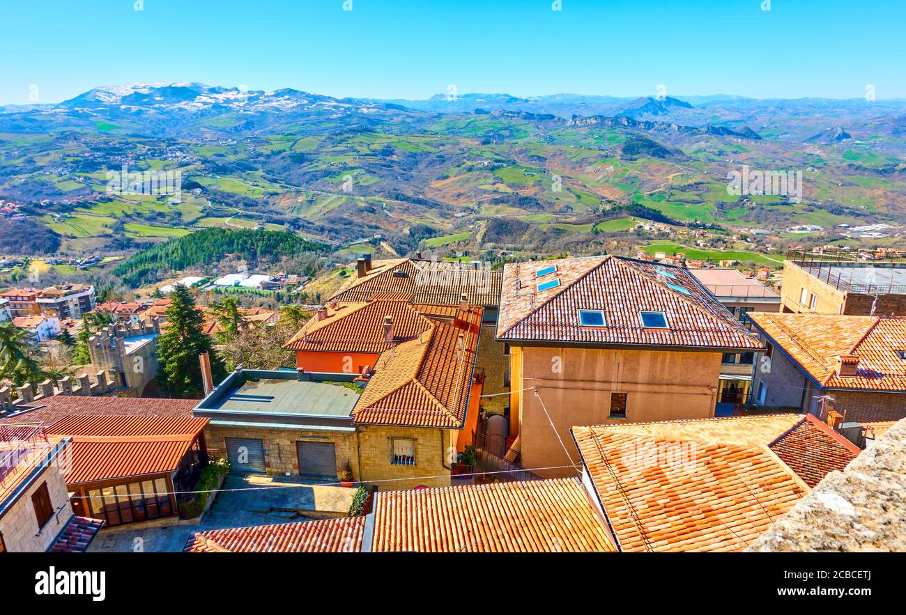 Tetti in tegole a San Marino e paesaggio con mountains in lo sfondo Foto Stock