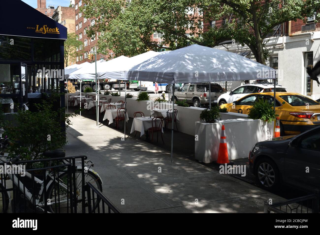 Tavoli e sedie allestiti sotto tende bianche su una strada cittadina, 11 agosto 2020, a New York. I ristoranti di New York sono ancora limitati ai soli ristoranti all'aperto. Foto Stock