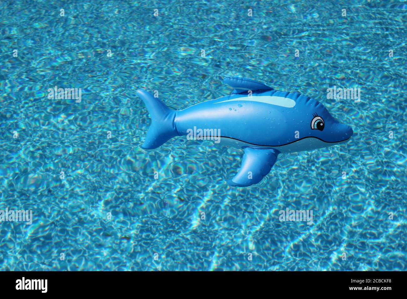 Acqua blu della piscina con un giocattolo di plastica per la piscina dei delfini Foto Stock