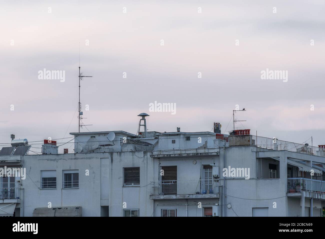 Sirena RAID aria di guerra sul tetto degli edifici residenziali. Vecchia sirena d'allarme a forma di fungo, tra antenne in cima alle case cittadine di Salonicco. Foto Stock