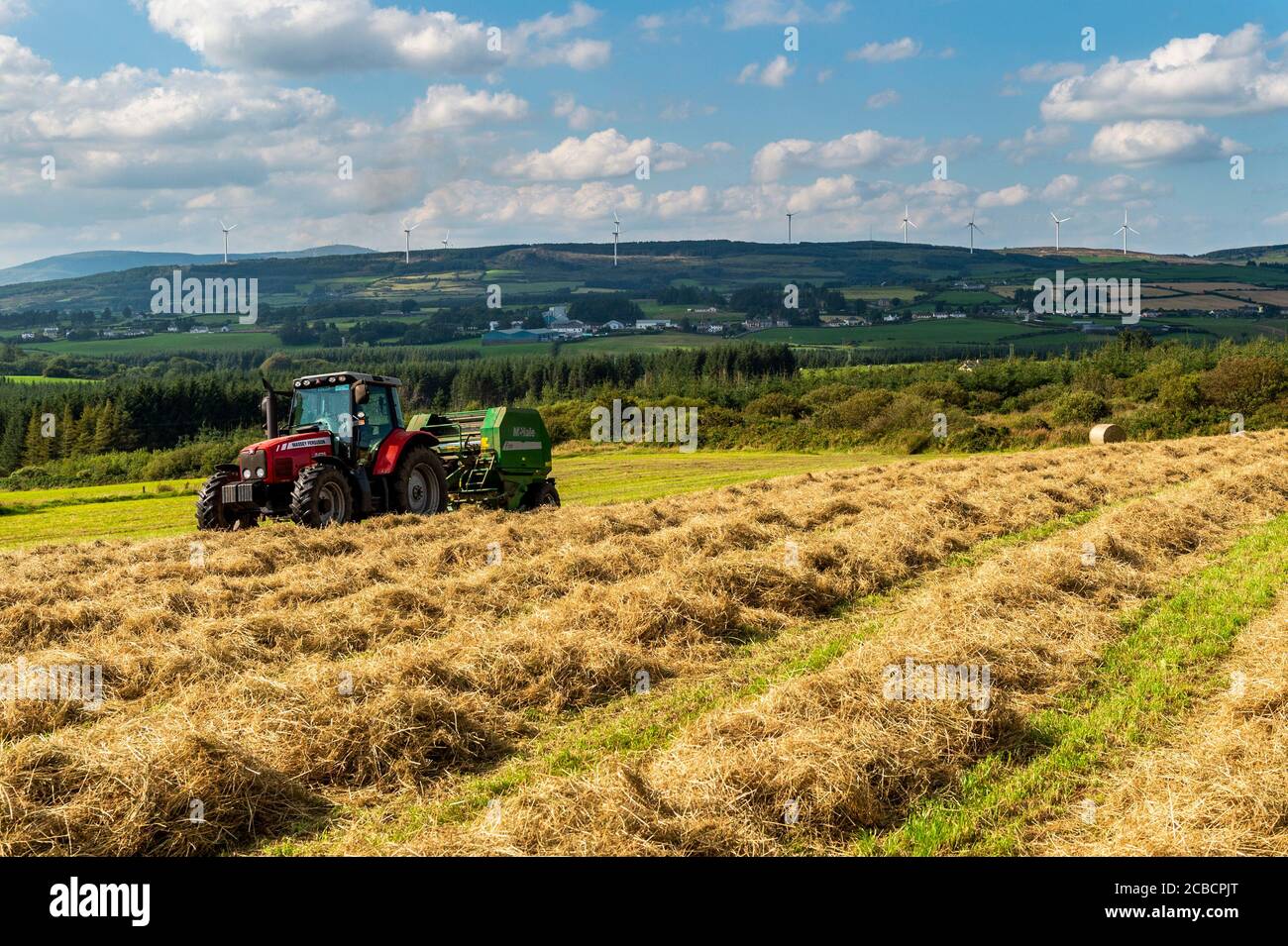 Drinagh, West Cork, Irlanda. 12 agosto 2020. Evan Wilson balla il fieno nella fattoria Drinagh di George Wilson utilizzando una pressa Massey Ferguson 6475 e McHale F550. Credit: AG News/Alamy Live News Foto Stock