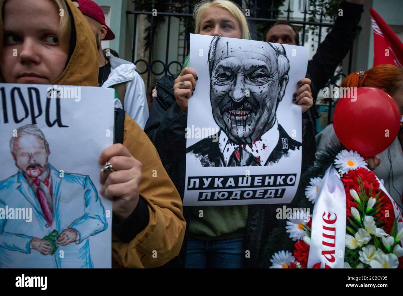 Mosca, Russia. 12 agosto 2020 le donne tengono cartelli raffiguranti il presidente bielorusso Alexander Lukashenko fuori dall'ambasciata bielorussa durante una protesta contro i risultati delle elezioni presidenziali bielorusse, a Mosca, in Russia. Il banner recita 'Lukashenko è un cannibale' Foto Stock