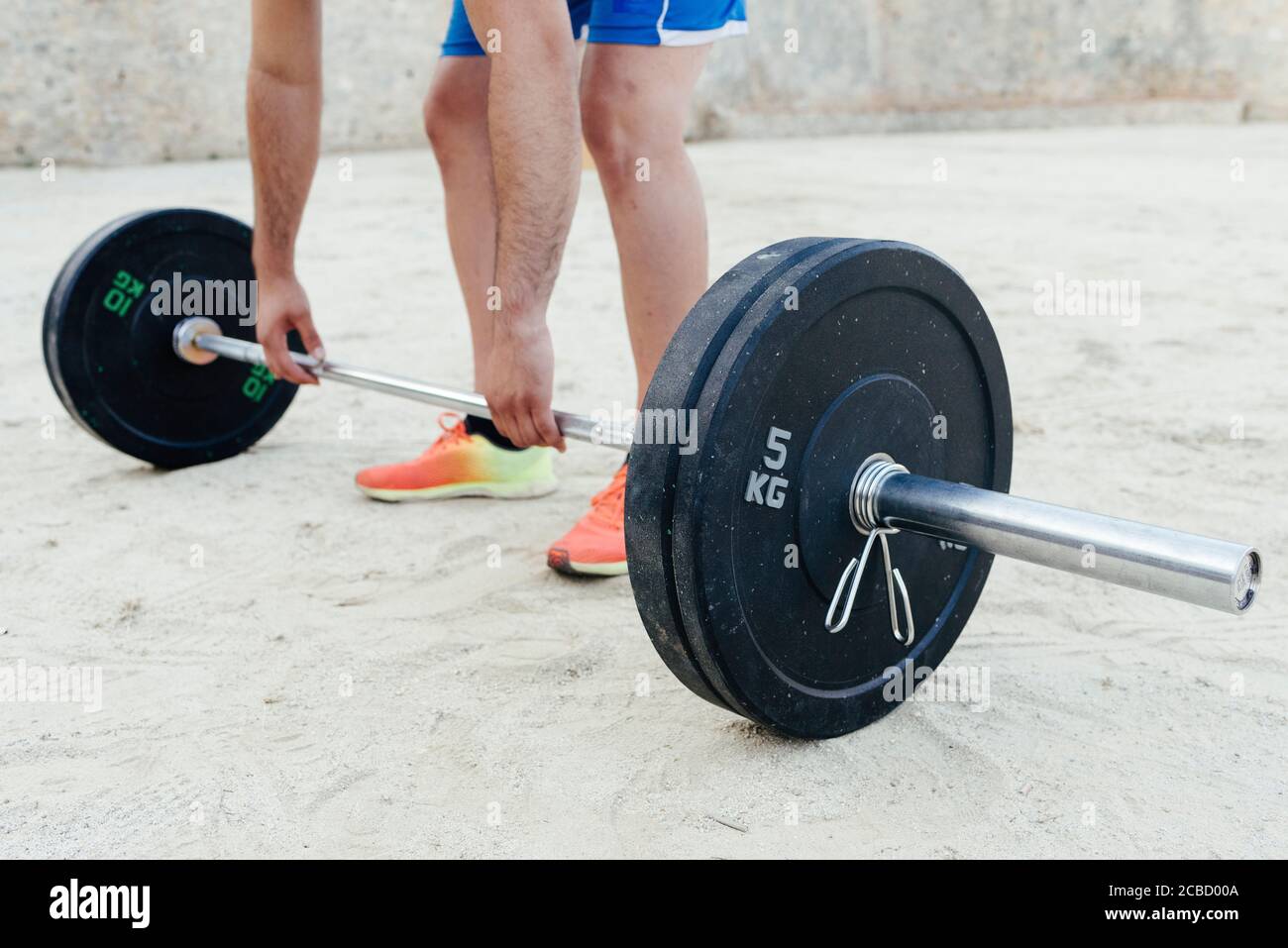 Primo piano di gambe e braccia di un sportivo che fa crossfit urbano Foto Stock