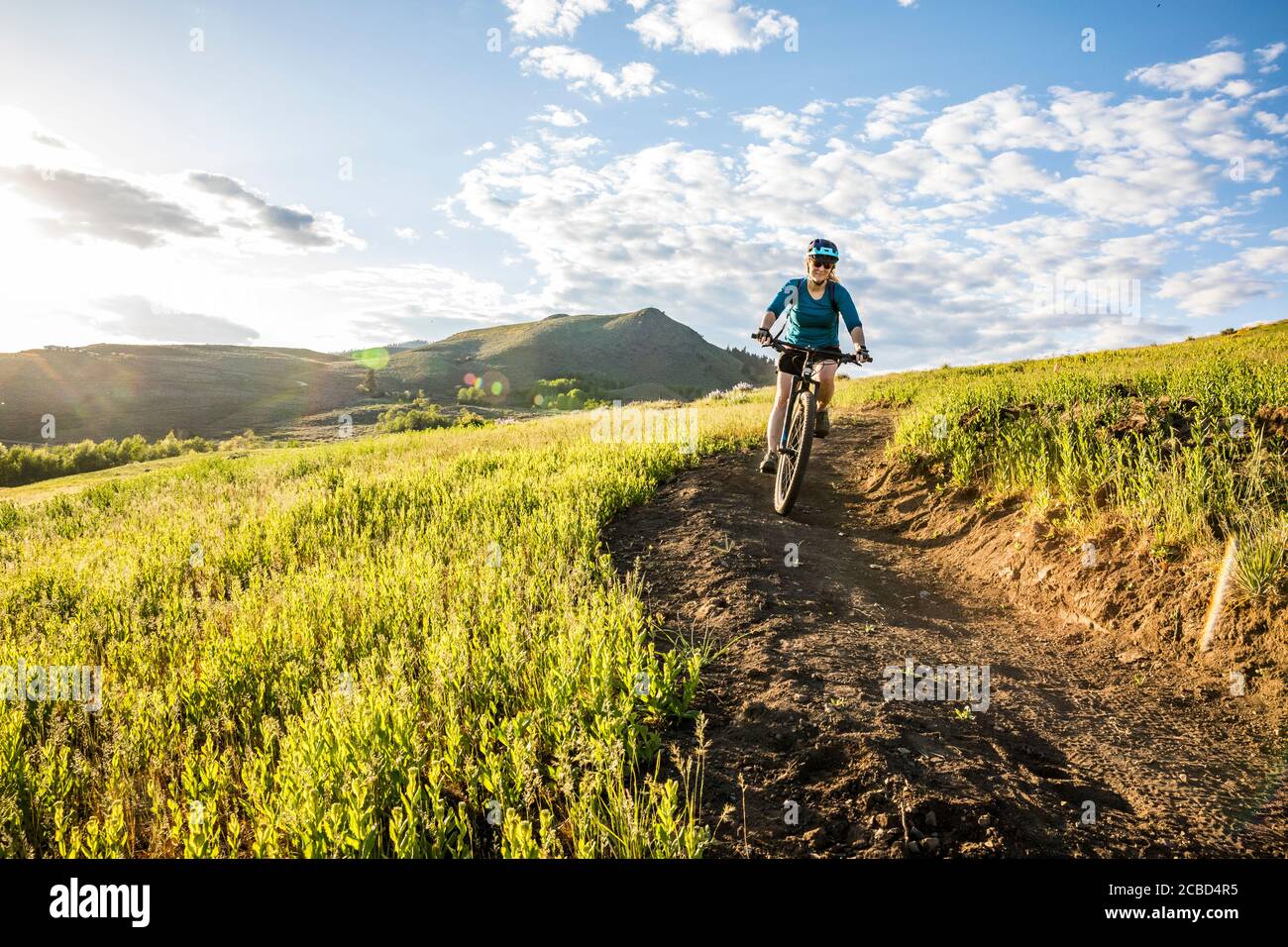 Una donna che sale sul sentiero di Lewis Butte fuori Winthrop, Washington in un pomeriggio soleggiato a maggio. Foto Stock