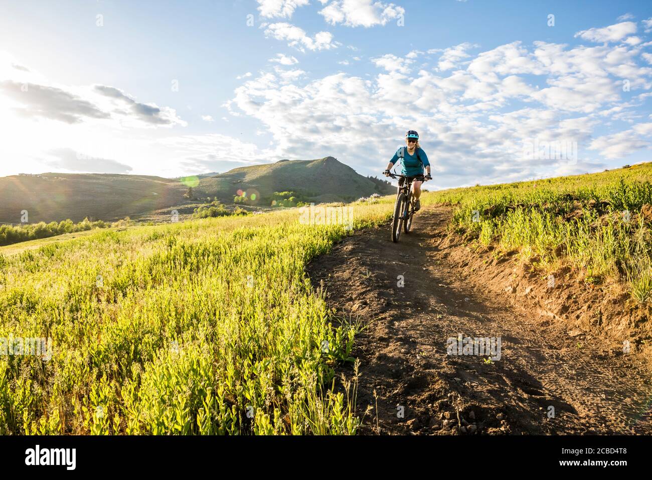Una donna che sale sul sentiero di Lewis Butte fuori Winthrop, Washington in un pomeriggio soleggiato a maggio. Foto Stock