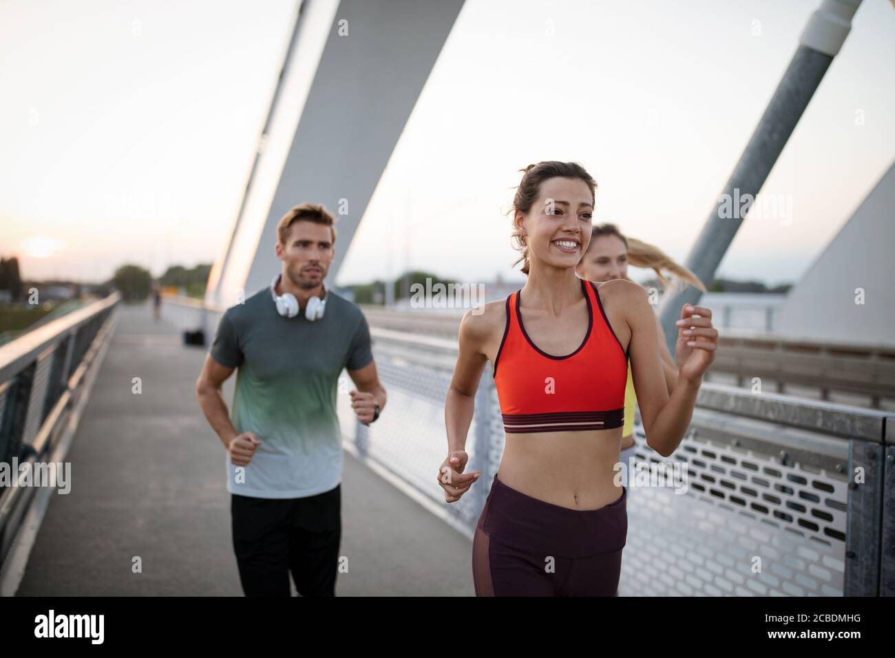 Montare atletico amici esercizio e jogging insieme all'esterno. Sport, gli amici, il concetto di salute Foto Stock