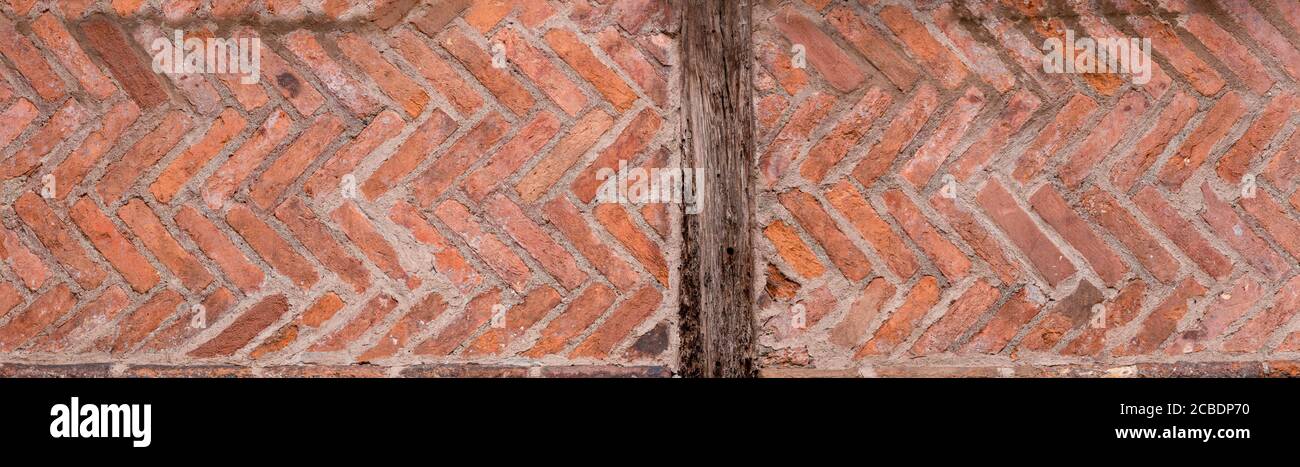 Antico muro di architettura romana con mattoni a spina di pesce Foto Stock