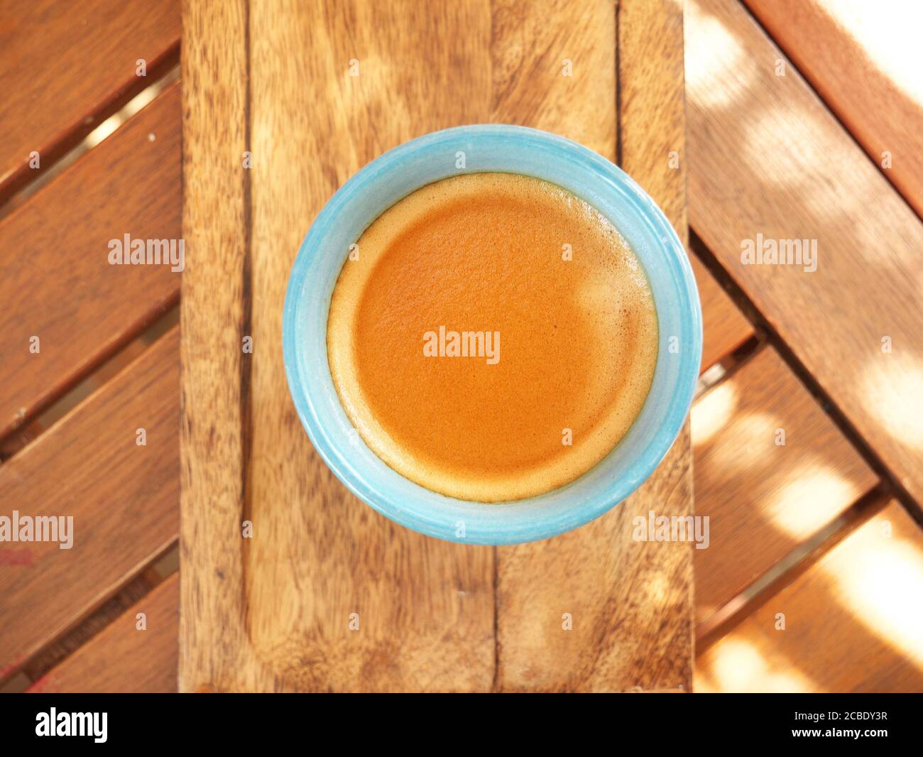 Primo piano di una tazza di caffè vista dall'alto su a. tavolo di legno Foto Stock
