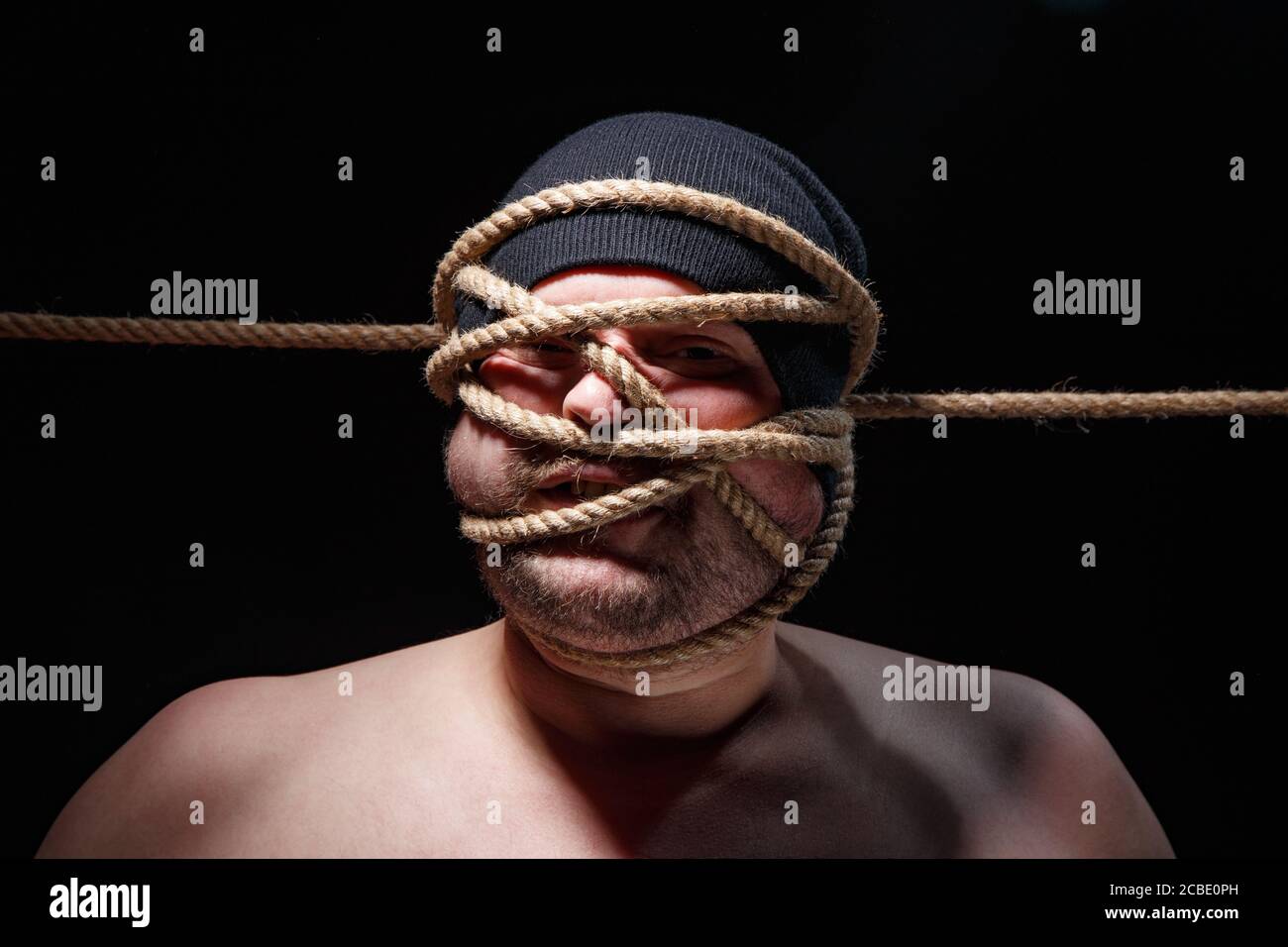 Immagine di un uomo grasso con corda sul viso Foto Stock