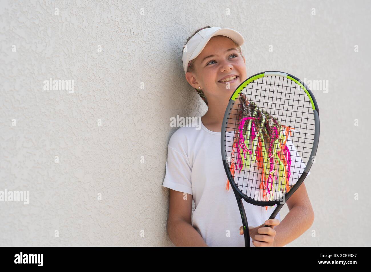 Principiante sorridente ragazza tennista con una racchetta da tennis in  mano Foto stock - Alamy