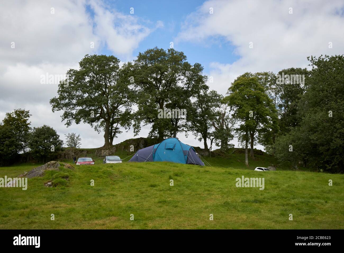 tenda e auto in un campeggio campo con persone in campeggio vicino al lago loughrigg distretto cumbria inghilterra regno unito Foto Stock