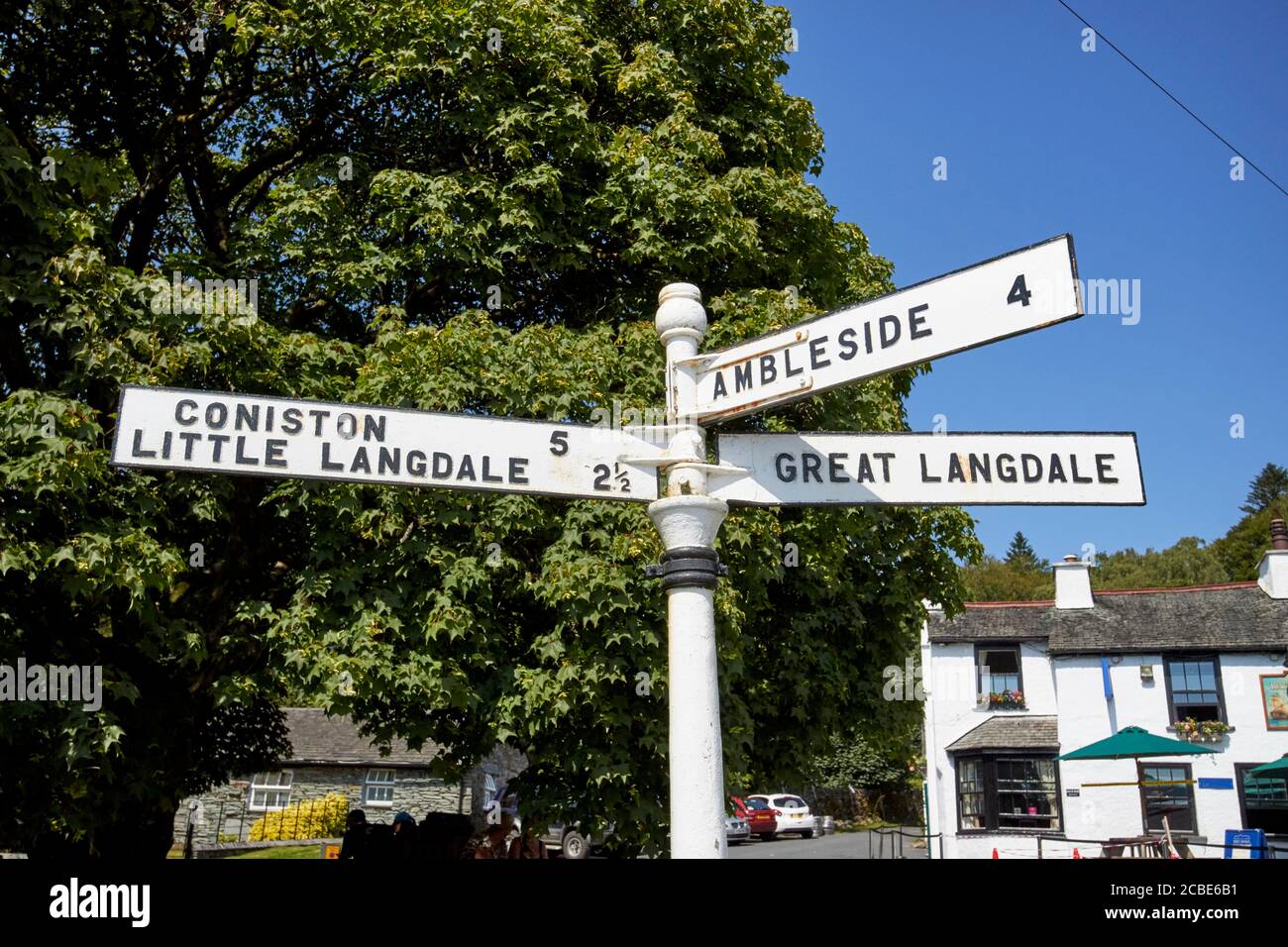 vecchio cartello in metallo con distanze da coniston little langdale ambleside e grande langdale nel distretto dei laghi di elterwater cumbria inghilterra uk Foto Stock