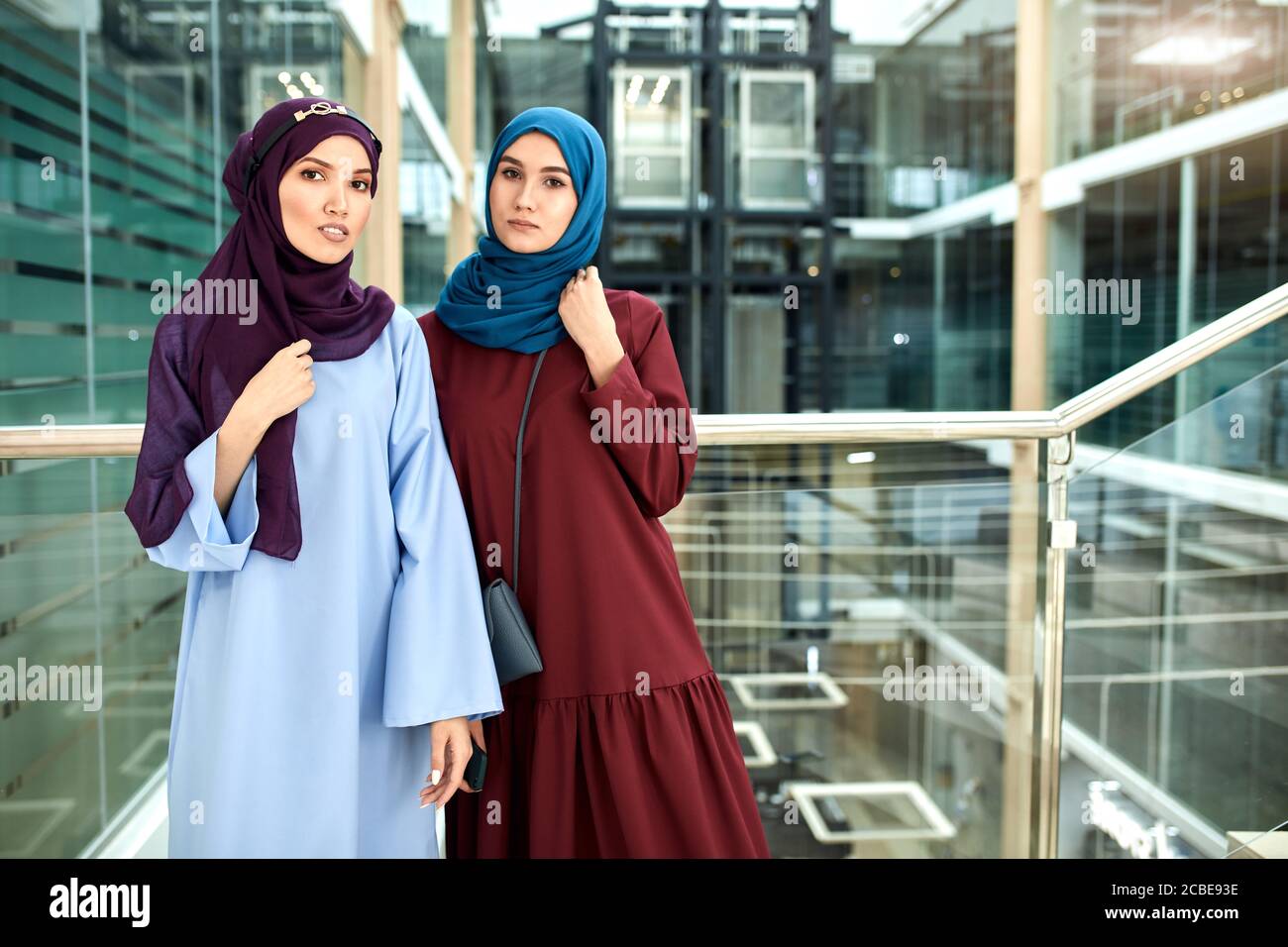 Ritratto di due giovani donne islamiche vestite di abiti musulmani con i  hijab sulla testa guardando