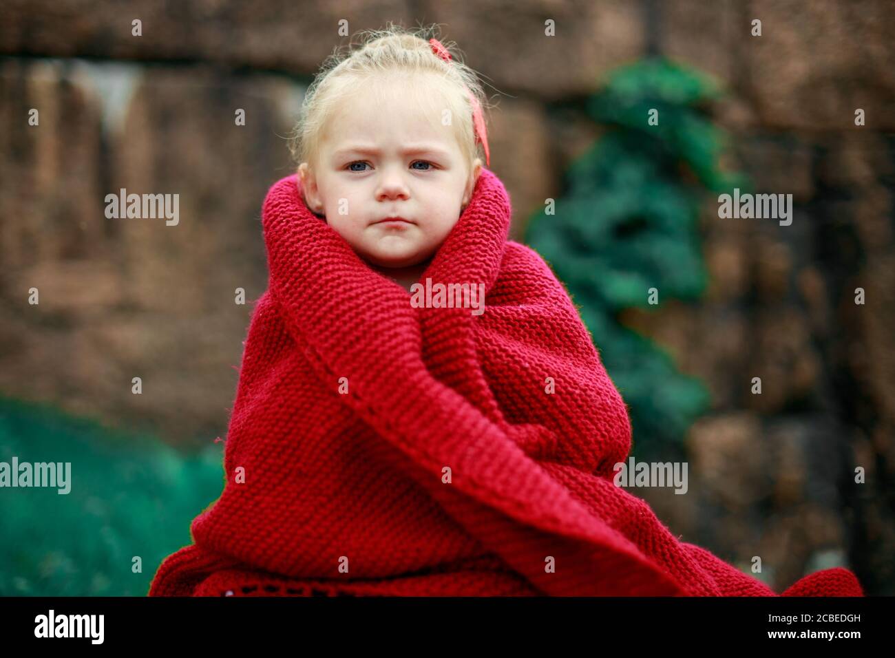 bambina nel parco avvolta in uno scialle di lana Foto stock - Alamy
