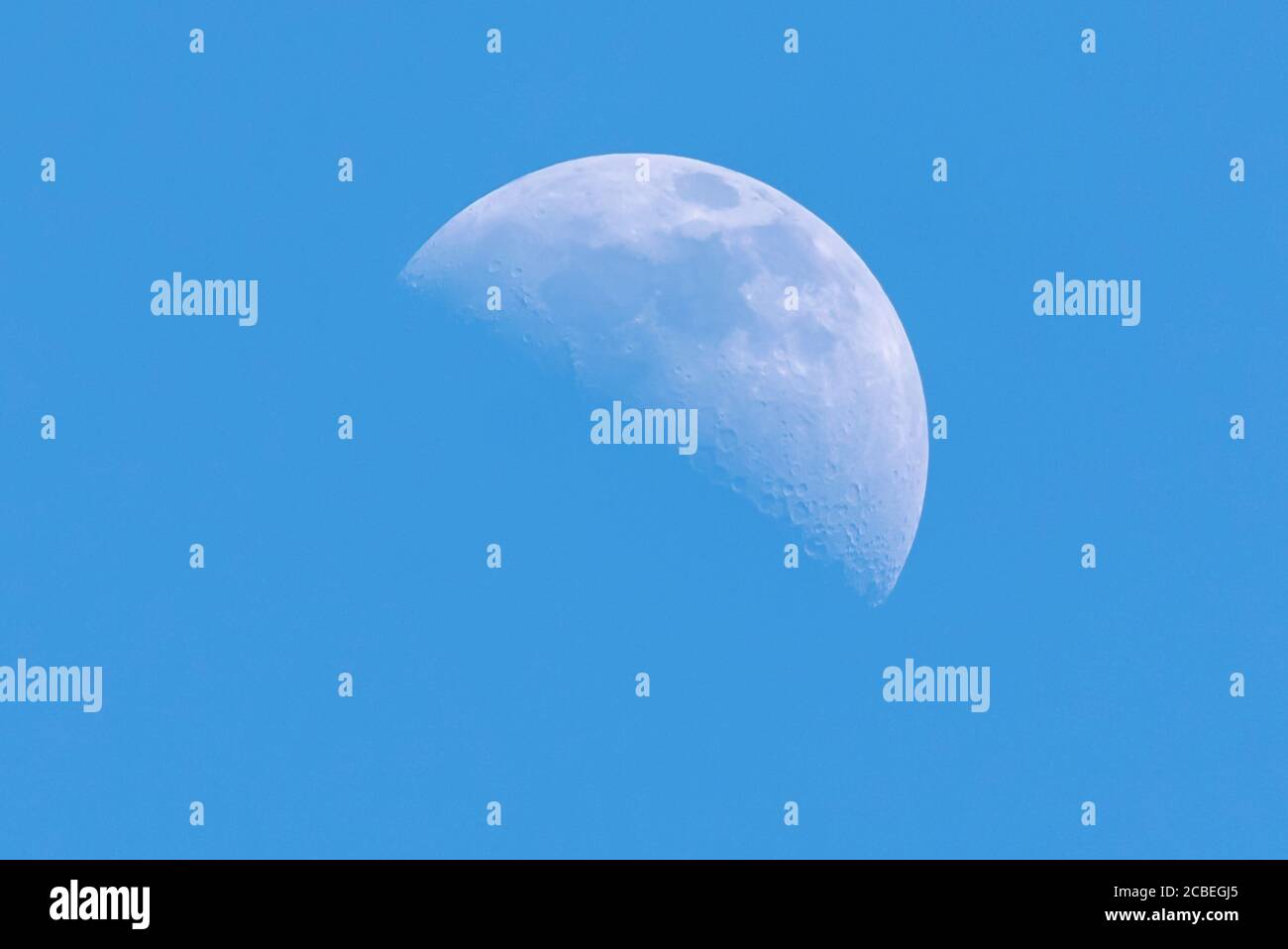 Luna diurna con sfondo blu Foto Stock