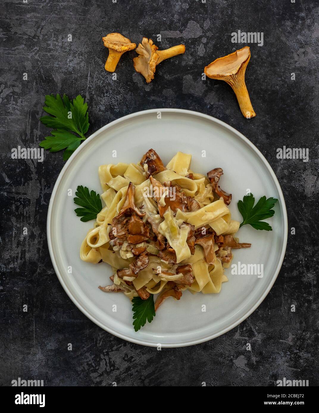 Vista dall'alto della pasta italiana Tagliatelle con funghi chanterelle una piastra bianca Foto Stock