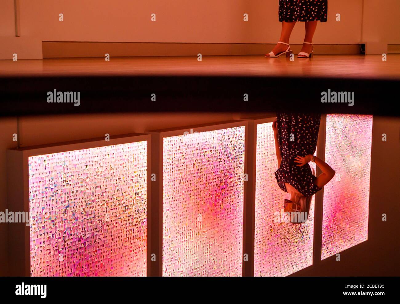 Un visitatore si riflette in un'opera d'arte mentre vede un'altra opera intitolata 'Murmurations n° 23: 10,000 selfie (con una parete rosa a Los Angeles)' dell'artista Stephanie Potter Corwin, che fa parte della mostra del Premio d'Arte Estetica in mostra alla York Art Gallery nello Yorkshire. Foto Stock