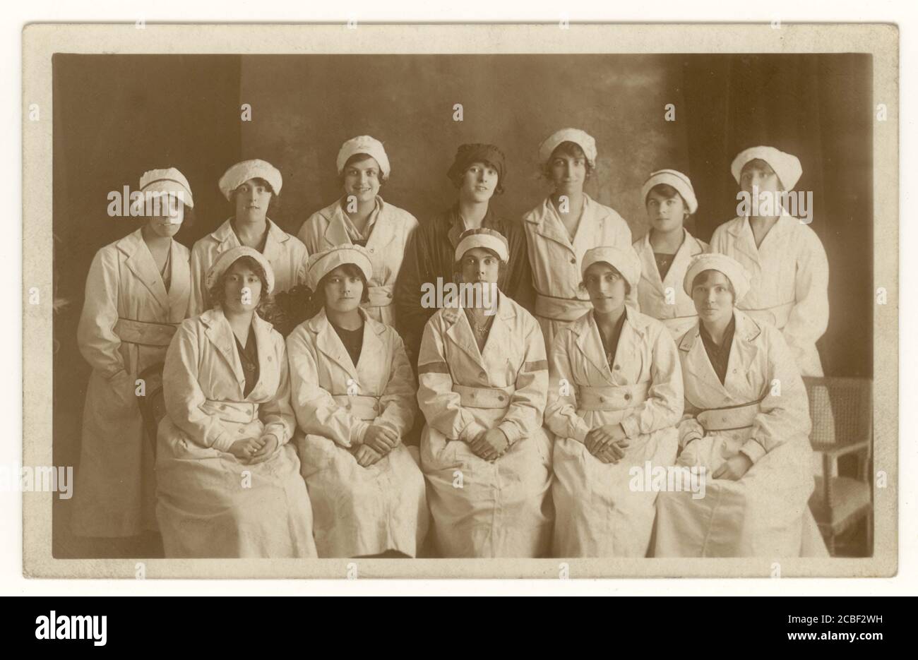 Post WW1 era cartolina di donne operai in fabbrica in uniformi bianche. Ricamato sul lapello e sul cappuccio è A.C.C. L'immagine risale a circa i primi anni '20, nel Regno Unito Foto Stock
