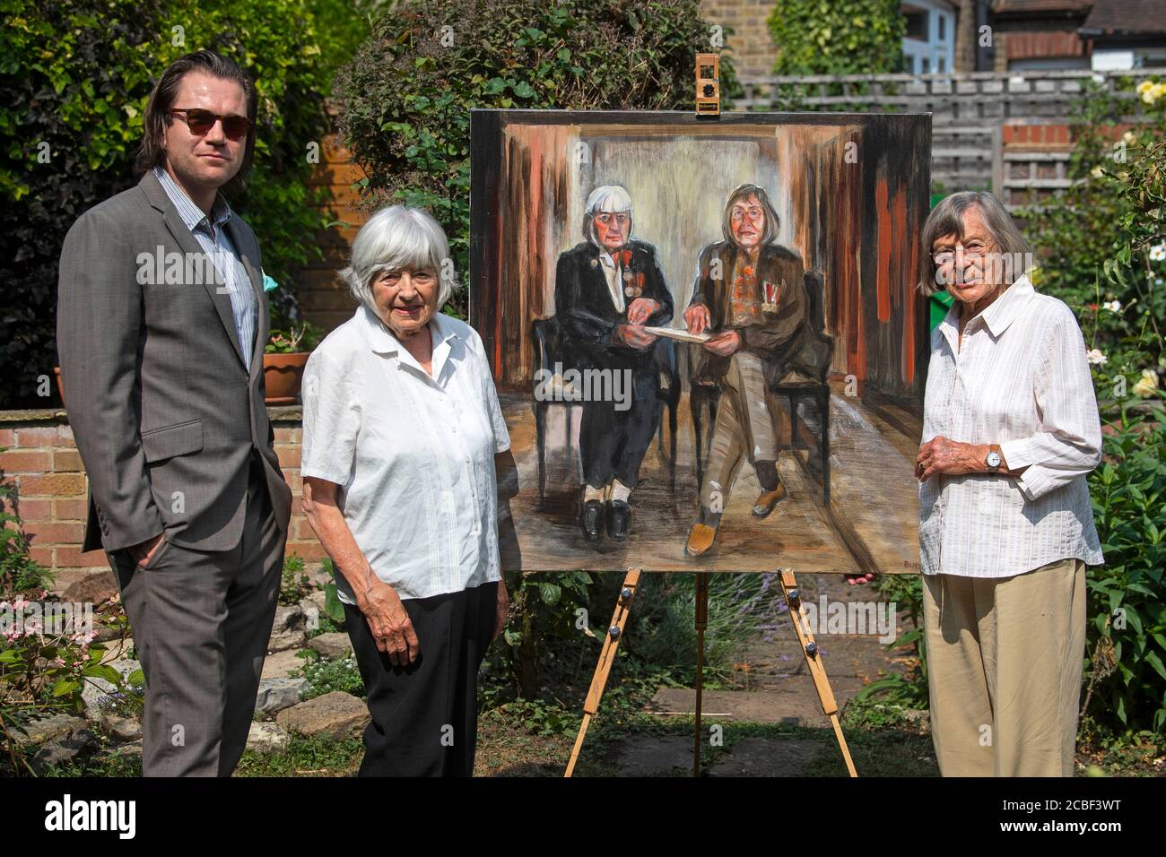 L'artista Dan Llywelyn Hall con Patricia DAVIE e Jean Argles (L-R), le ultime sorelle viventi ad aver firmato l'Official Secrets Act nella seconda guerra mondiale, mentre svelano il loro ritratto dall'artista a Londra ovest, in vista del VJ Day. Foto Stock